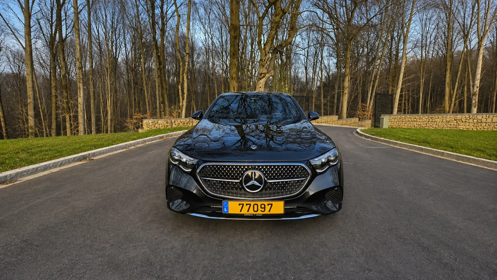 Mercedes Classe E noire vue de face sur une route forestière au Luxembourg